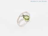 a close up of a ring with a green tourmaline and diamonds