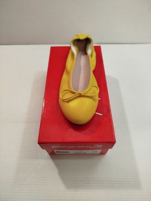 une chaussure jaune posée sur une boîte rouge