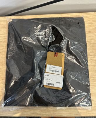 un sac en plastique muni d'une étiquette, posé sur une table en bois