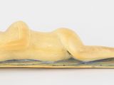 une figurine représentant une femme allongée sur une couverture