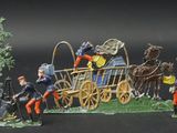 figurines of a group of people riding on top of a horse drawn carriage