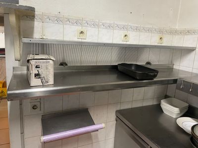 une cuisine équipée de plans de travail en inox et d'un lave-vaisselle