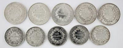 six different types of silver coins are arranged on a white surface