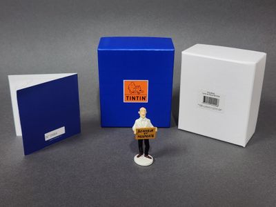 deux petites figurines représentant un homme tenant une boîte et une boîte remplie de livres