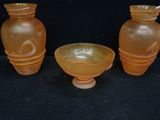 three vases sitting next to each other on a black surface