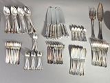 many spoons and forks laid out on the table