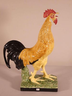 a figurine of a rooster on a green base