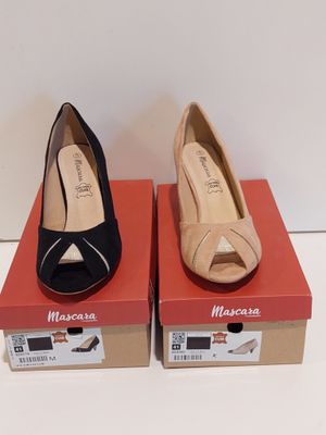 deux paires de chaussures noires et beiges posées sur des cartons