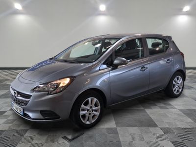 the gray car is parked on a checkered floor in the garage