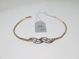 une photo d'un bracelet en or orné d'un nœud