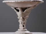 a white bowl with a bird on it on a table