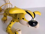 a toy of a yellow and black cat on a white surface