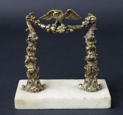 une figurine ancienne en métal argenté représentant deux oiseaux, posée sur un socle en marbre