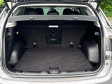 l'arrière d'une voiture dont le coffre est ouvert, un jour de pluie