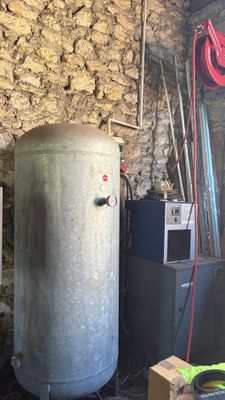 un grand réservoir métallique posé dans un coin d'une pièce