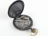an old pocket watch with a key in it on a white surface