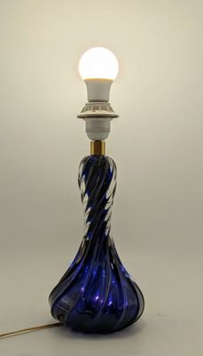 a blue glass lamp that is on a white table