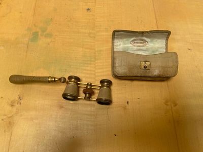 un portefeuille et une paire de jumelles posés sur une table