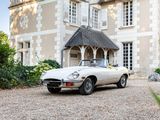 a white sports car parked in front of a large house