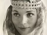 an old black and white photo of a woman wearing a headdress