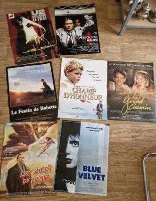 de nombreuses affiches de cinéma posées sur la table à côté d'une chaise