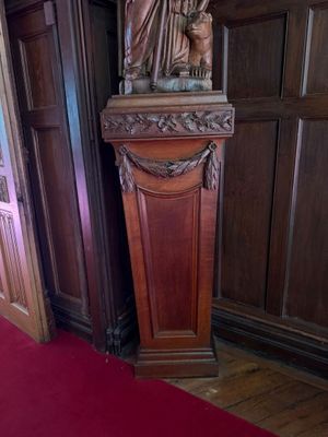 une statue représentant une femme debout sur un socle, dans une pièce