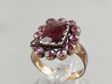 a close up of a ring with a red stone in it