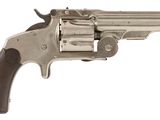 un vieux revolver avec un manche en bois sur fond blanc