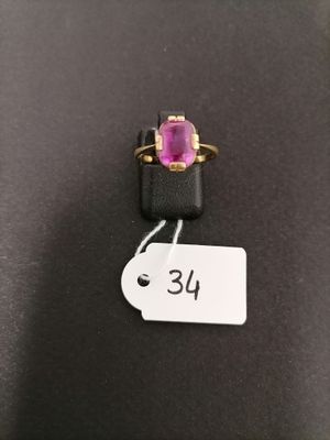 a close up of a pink stone ring on a black surface