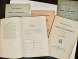 plusieurs livres ouverts posés sur une table, elle-même posée sur une autre table