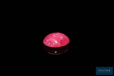 des tourmalines roses dans un bol noir posé sur une surface noire