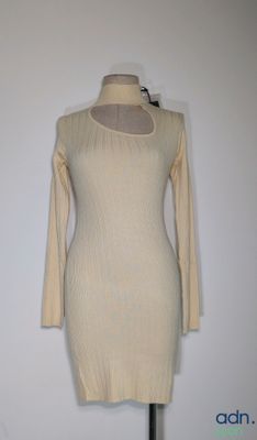 La robe est posée sur un support de mannequin, avec un mur blanc en arrière-plan.