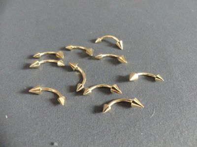 six small gold dolphins are sitting on a black surface