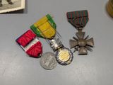 three medals and a medal on a table with a picture of a soldier in the background