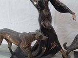 a statue of a woman and two dogs on a table