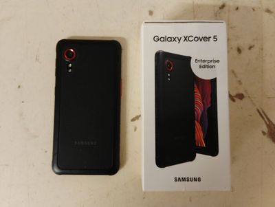 l'emballage d'un téléphone Samsung noir posé à côté d'une boîte sur une table