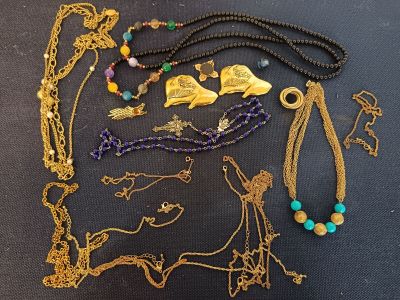 many different necklaces and bracelets laid out on a table