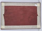 an old book with a red cover sitting on top of a white table