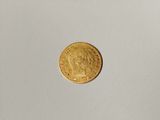 a close up of a gold coin on a white surface
