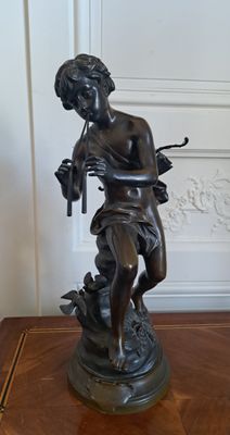 une statue représentant une femme tenant un oiseau sur une table