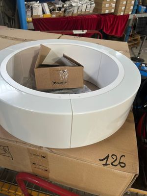 un grand saladier blanc posé sur une boîte en carton
