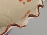 a vase with an orange and white design on it