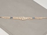 un gros plan d'un bracelet orné de perles et de pierres bleues