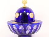 a blue glass bowl with a gold decoration on top