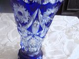 un vase en verre bleu posé sur une table, avec une étiquette de prix dessus