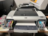 une imprimante posée sur un bureau, avec une autre imprimante à côté