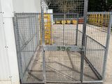 a large metal cage with a gate in front of a building