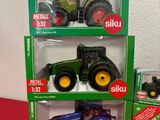 three toy tractors in the boxes on the table