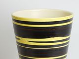 yellow and black striped cup on a white background