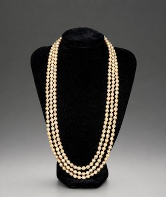 a three strand pearl necklace on a mannequin display